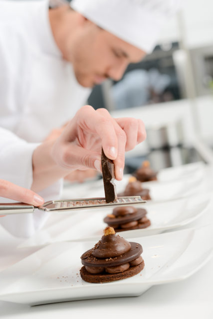 Pâtissier de restaurant en train de dresser des desserts