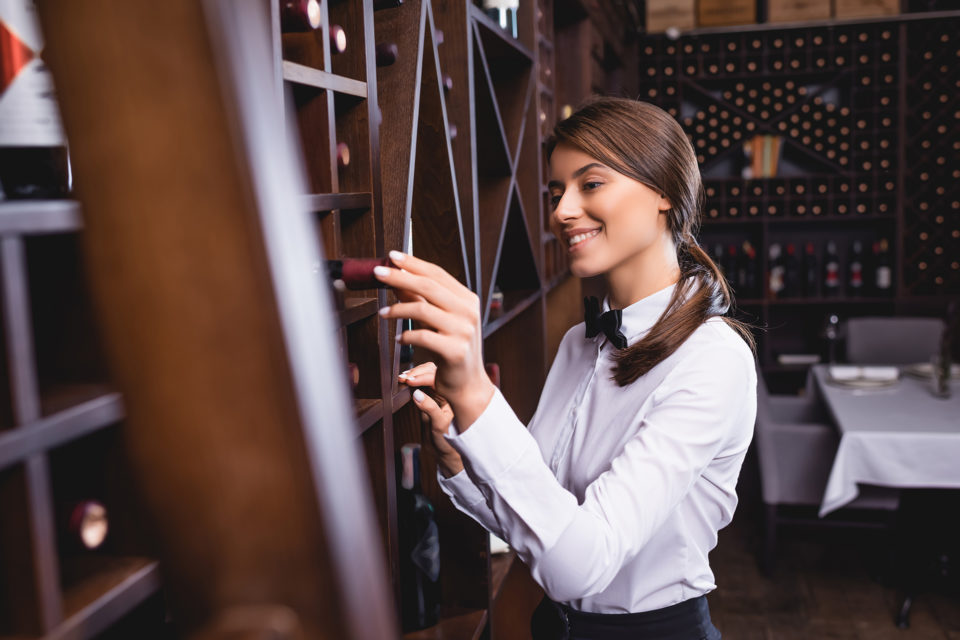 Sommelière en train de sélectionner une bouteille de vin